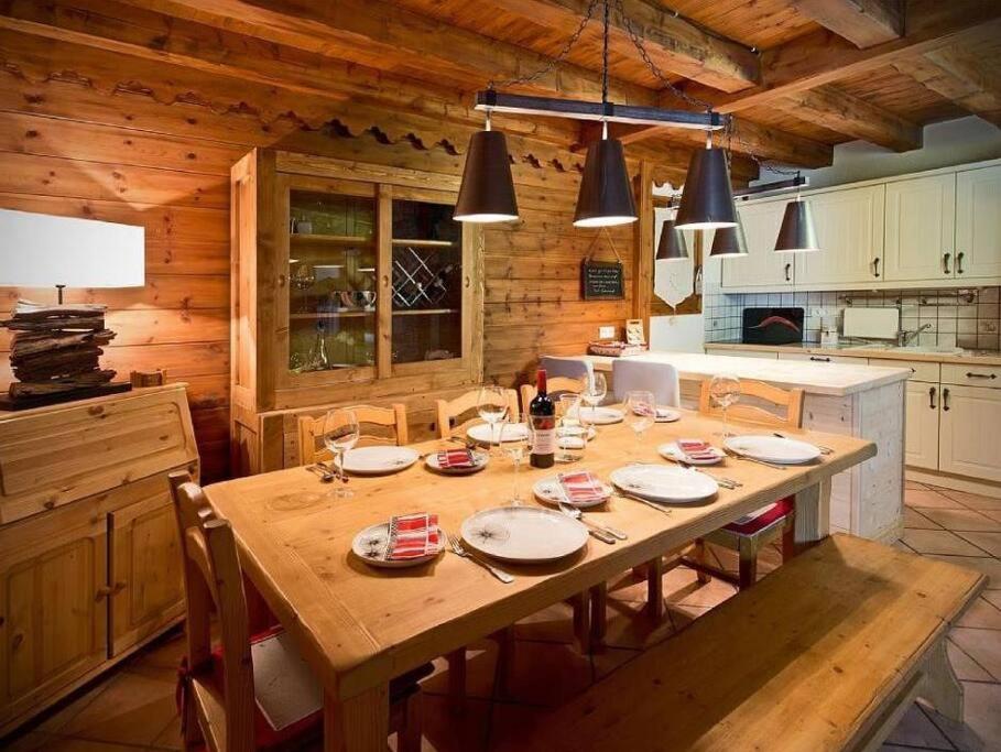 a dining room with a wooden table in a kitchen at Meribel Les Allues Ski Chalet with beautiful views in Les Allues