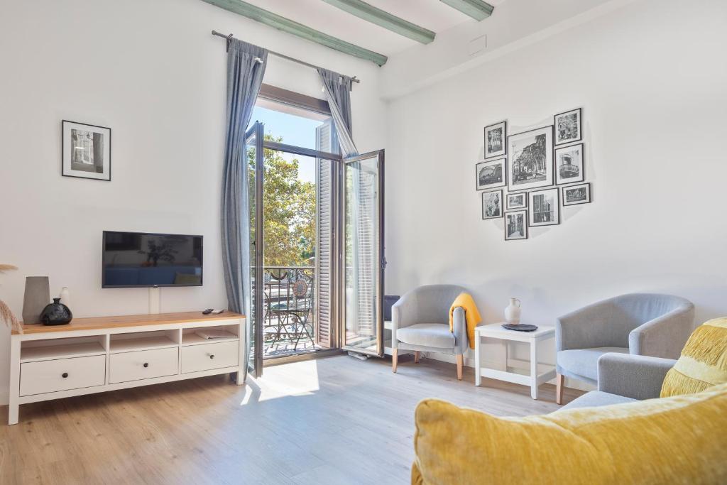 a living room with a couch and a tv and a window at Citytrip Barceloneta Beach in Barcelona