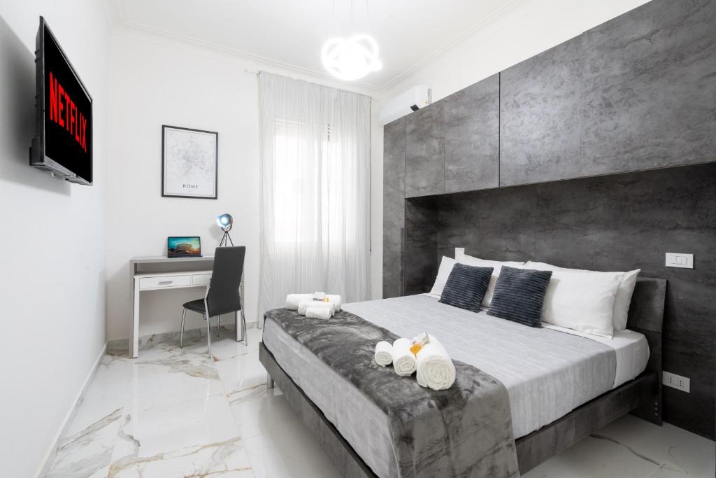 a bedroom with a large bed and a desk at [8 Minutes from the Centre] A/C -Wi-Fi and Netflix in Rome