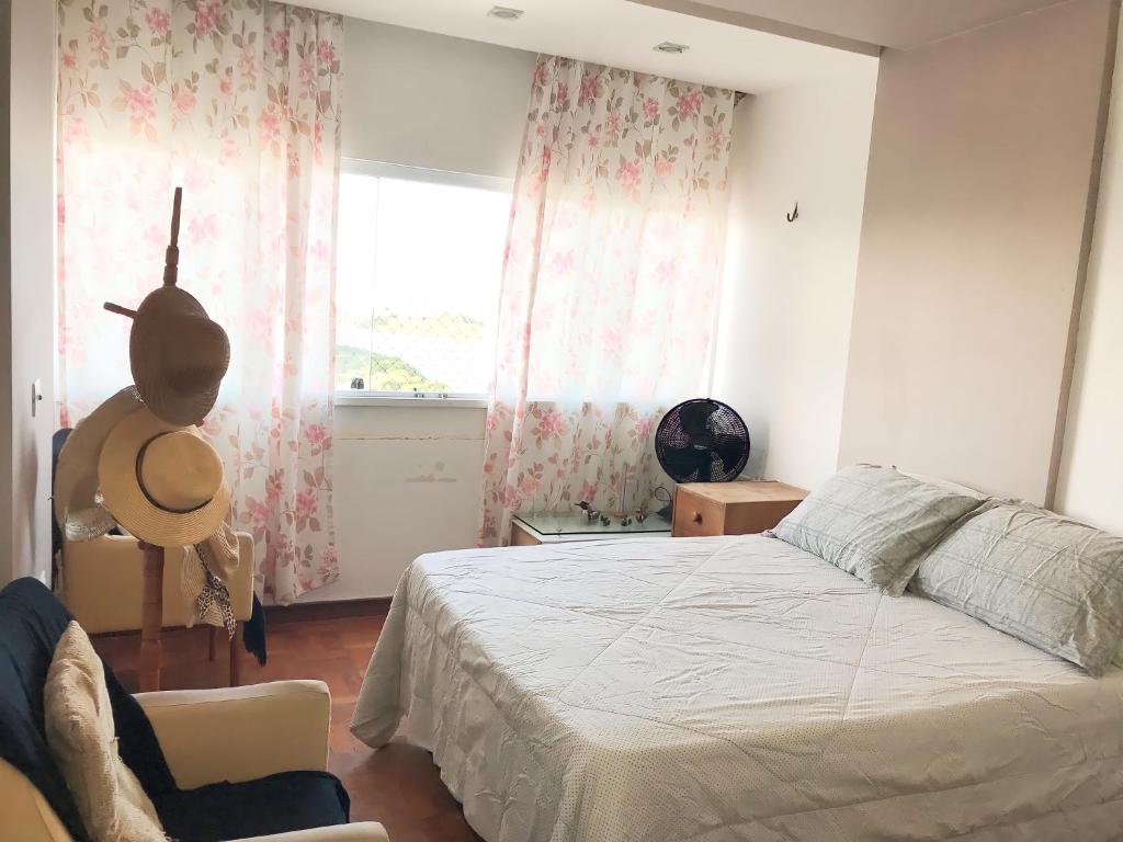 um quarto com uma cama, uma cadeira e uma janela em Aconchegante, ótima localização e vista para o mar no Recife