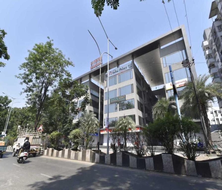 a man riding a motorcycle in front of a building at Hotel Infini Palace City Center in Surat