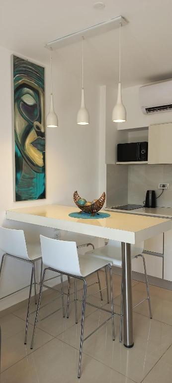 a kitchen with a table and chairs and a painting at המקום של אורלי in Eilat