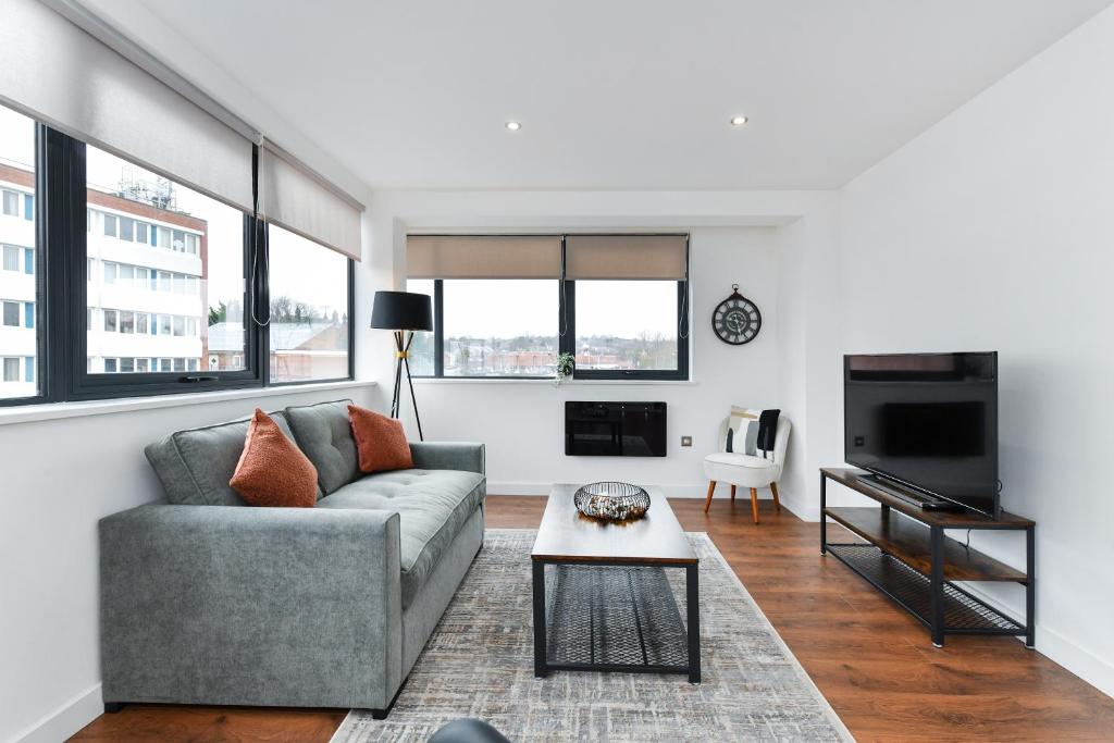 ein Wohnzimmer mit einem Sofa und einem Tisch in der Unterkunft Carlton Heights - A beautiful, inviting and modern 2 bedroom apartment, perfect for corporate stays and leisure in Nottingham