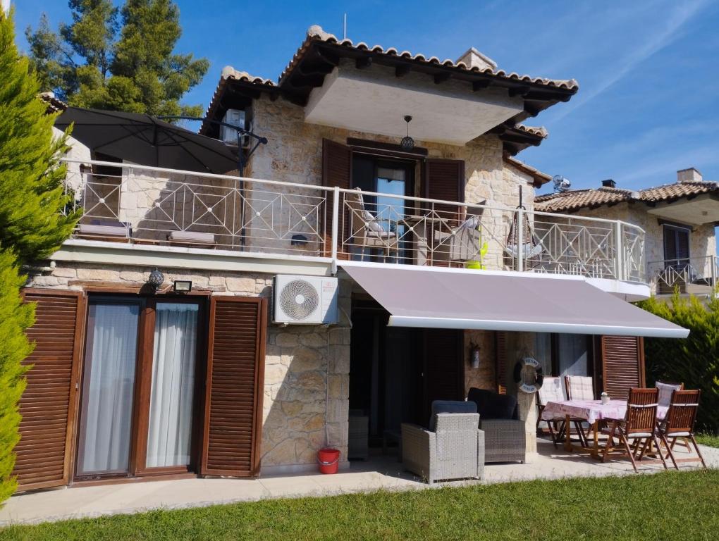 a house with a white awning and a patio at STONE Villa in Siviri