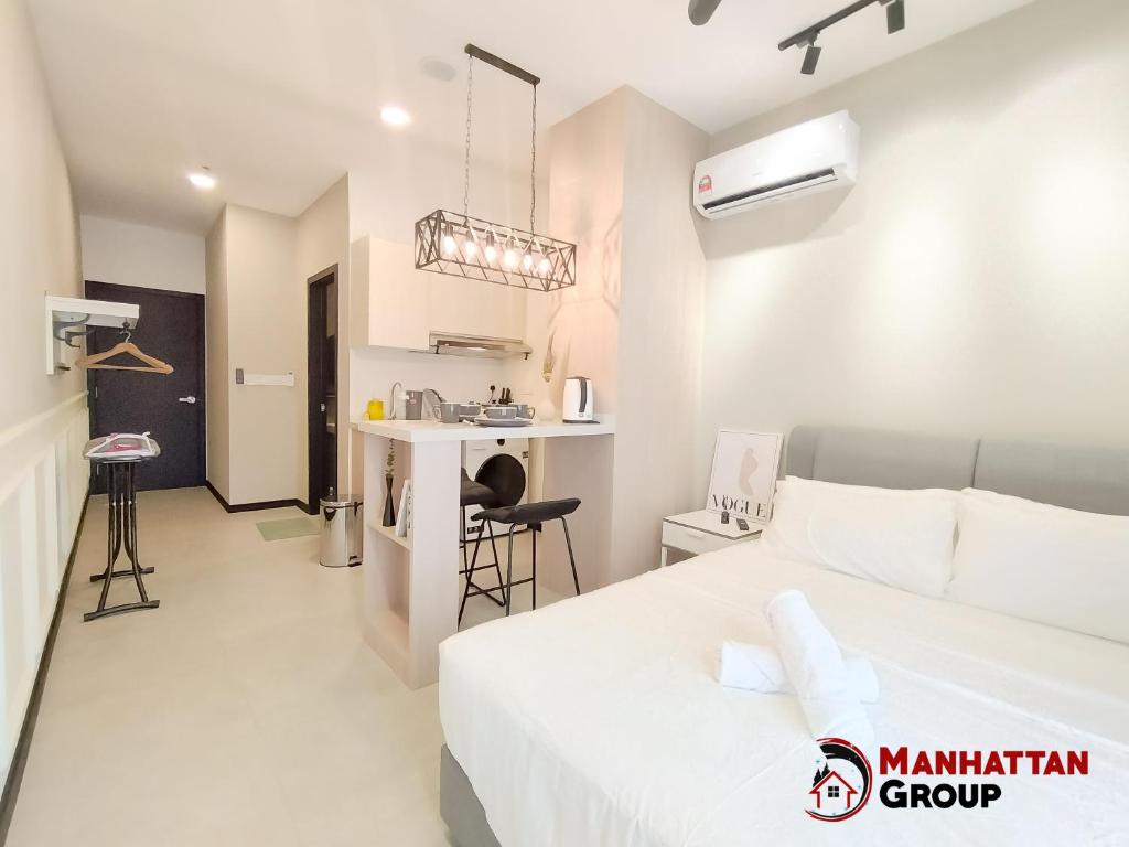 ein Schlafzimmer mit einem Bett und eine Küche in einem Zimmer in der Unterkunft Neu Suites By Manhattan Group in Kuala Lumpur