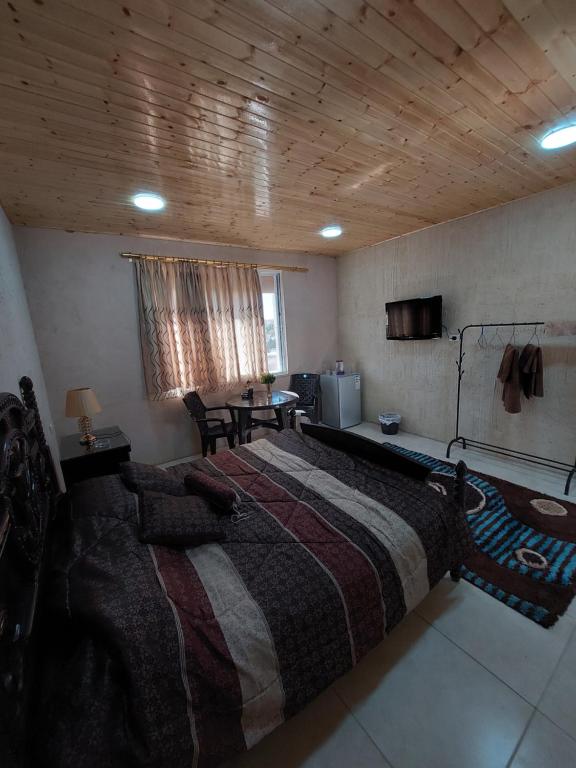 a large bed in a room with a wooden ceiling at Green Garden Rooftop in Madaba