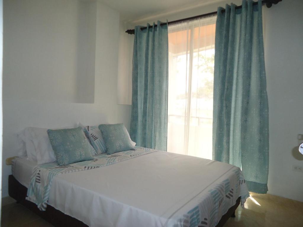 sypialnia z dużym łóżkiem i oknem w obiekcie APARTA-ESTUDIO LA TOMA w mieście Neiva