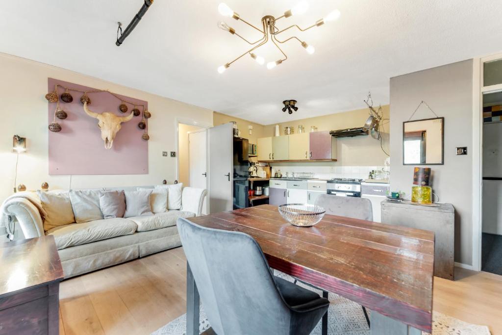 cocina y sala de estar con mesa y sofá en Pass the Keys - Modern flat in North Central London, en Londres