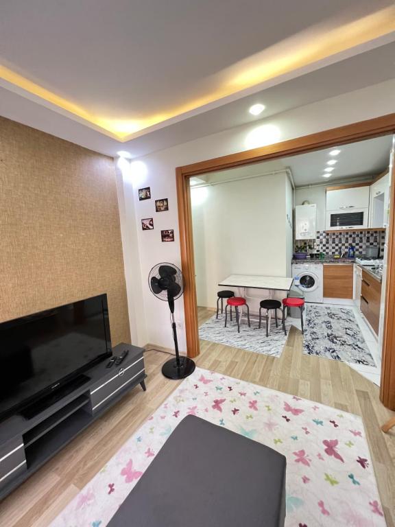- un salon avec une télévision et une table avec des chaises dans l'établissement Şirinlevler /Büyük /Daire TEMİZ, à Istanbul