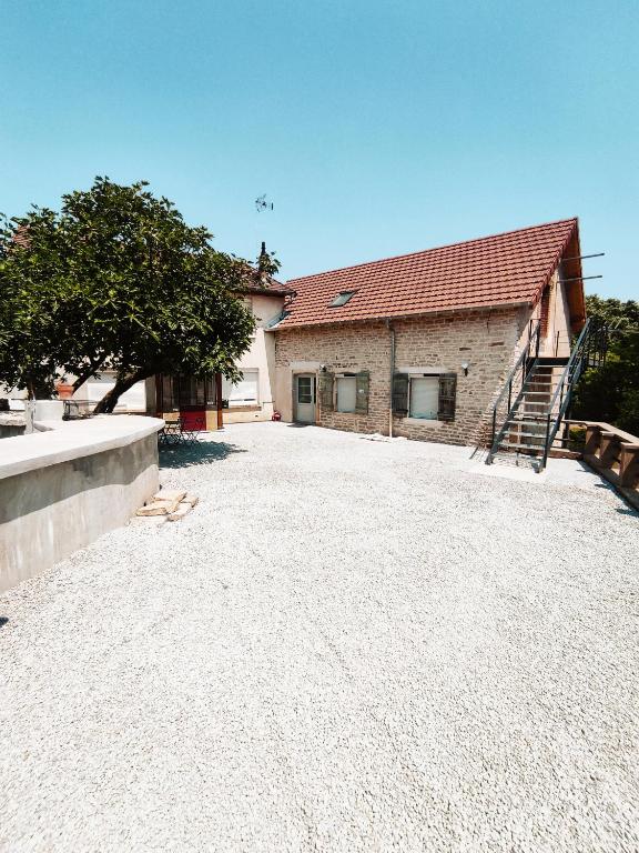 une maison avec une allée en gravier à côté d'un bâtiment dans l'établissement The Moulin Brochat Loft with jacuzzi area, à Saint-Jean-de-Vaux