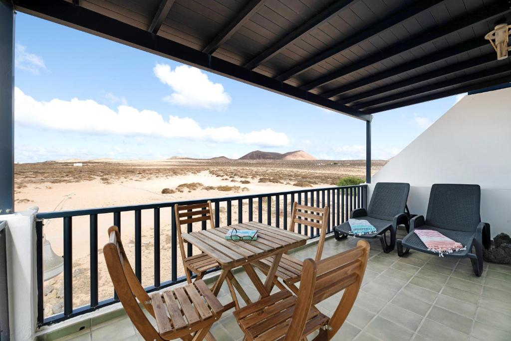 balcón con mesa y sillas en la playa en Apartamento Cabo, en Caleta de Sebo