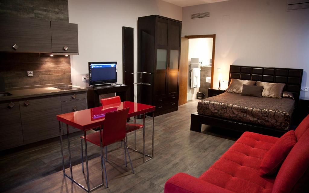 a bedroom with a bed and a red table and chairs at Hotel Alfonso IX in Cáceres