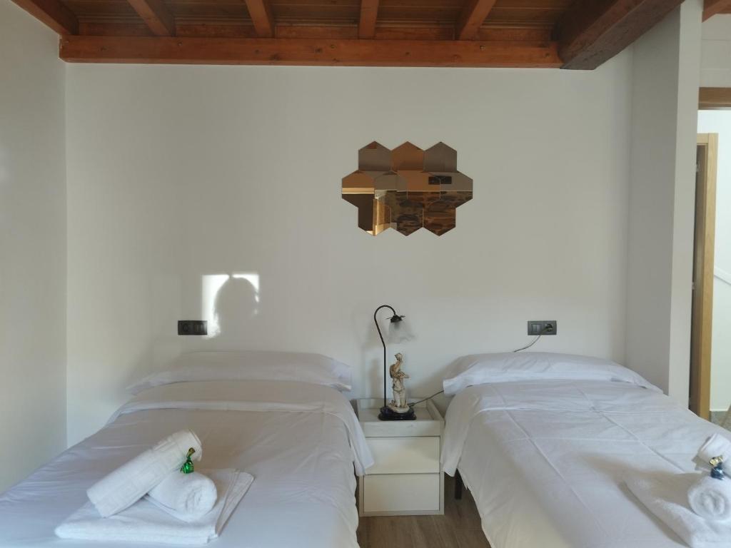 two beds in a room with white sheets and towels at Lazzaretto vivienda uso turístico in Lugo