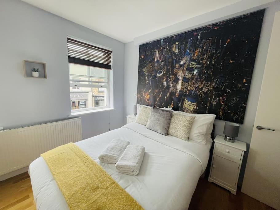 een slaapkamer met een groot wit bed en een groot raam bij The Hampstead Residence in Londen