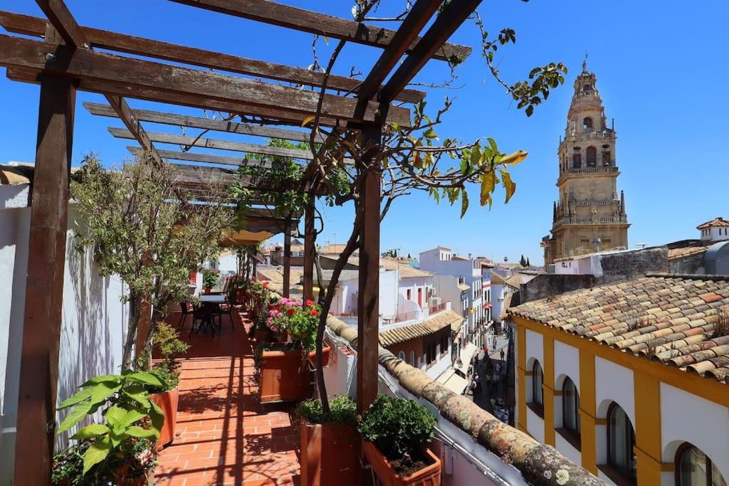 een uitzicht vanaf het balkon van een gebouw met een klokkentoren bij Casa con encanto en la judería de Córdoba in Córdoba