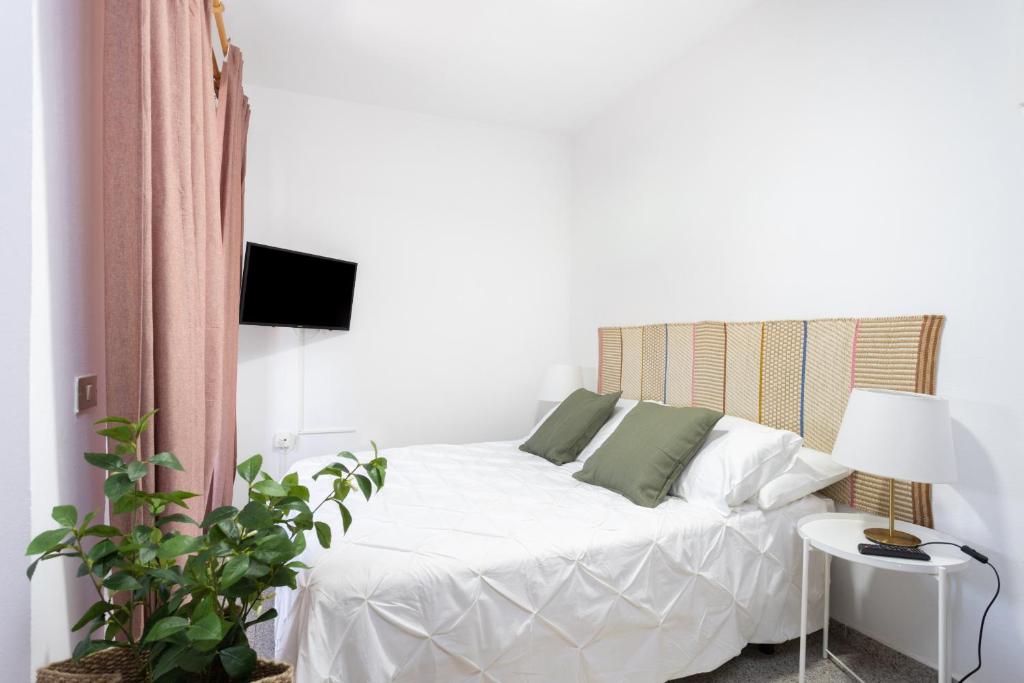 ein Schlafzimmer mit einem weißen Bett, einem Tisch und einer Lampe in der Unterkunft EDEN RENTALS 106 Surfy Stylish Bed&Coffee Room in Granadilla de Abona