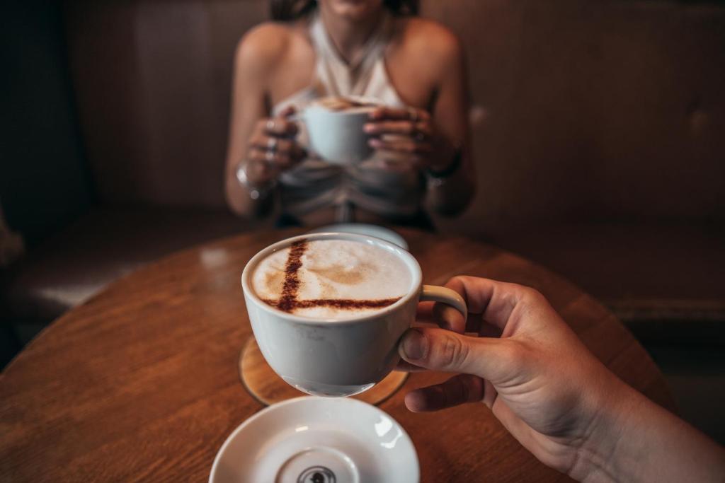 a woman sitting at a table with a cup of coffee at The Cock and Magpie in Bewdley