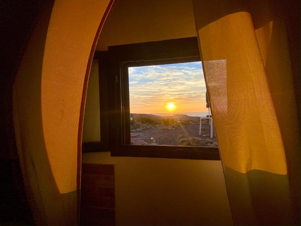 Guest House Calalunga Scogliera في كارلوفورتي: نافذة في غرفة مطلة على غروب الشمس