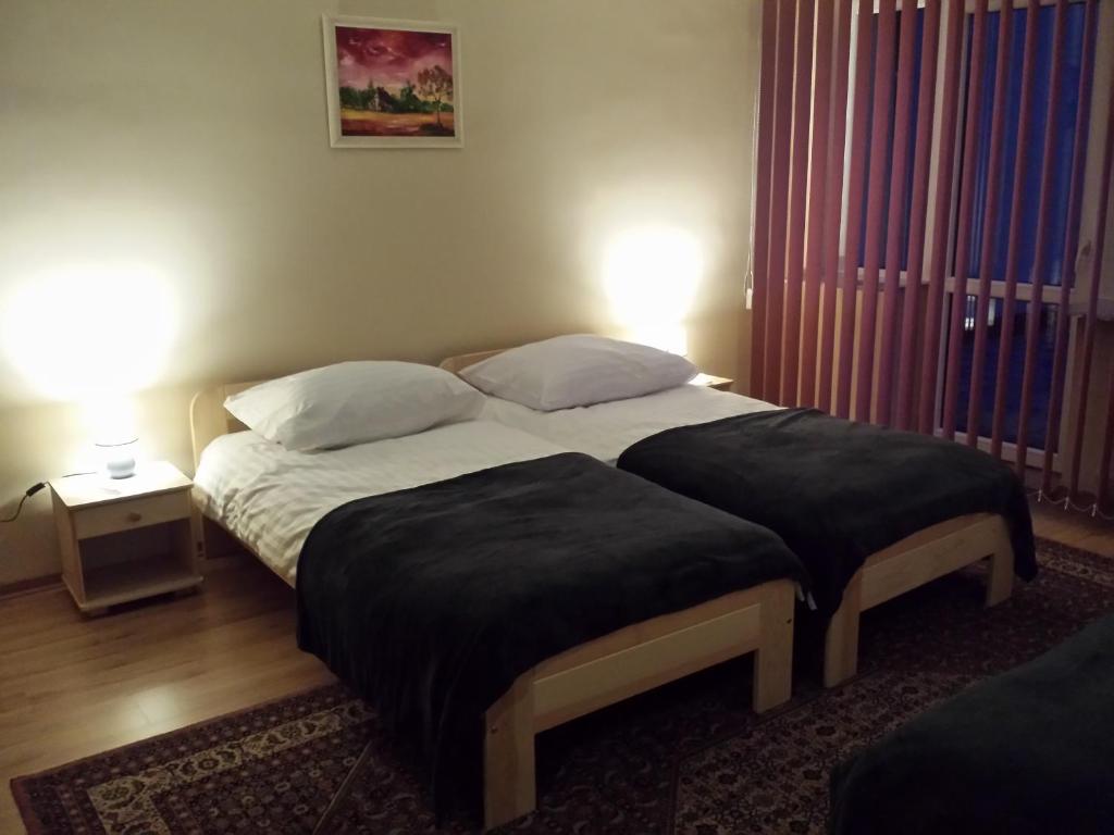 a bedroom with a large bed with two pillows at Pokoje gościnne vis a vis Retro in Gostynin