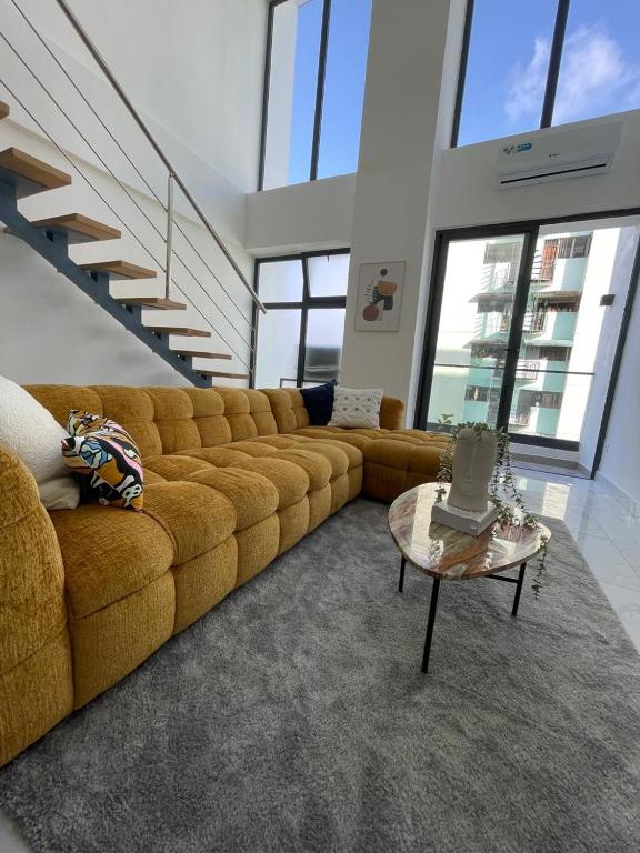 a living room with a large couch and a table at Agreable Duplex tout confort. in Santo Domingo