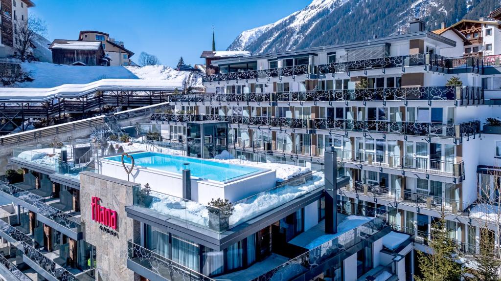an apartment building with a swimming pool in the snow at Hotel Fliana Ischgl in Ischgl