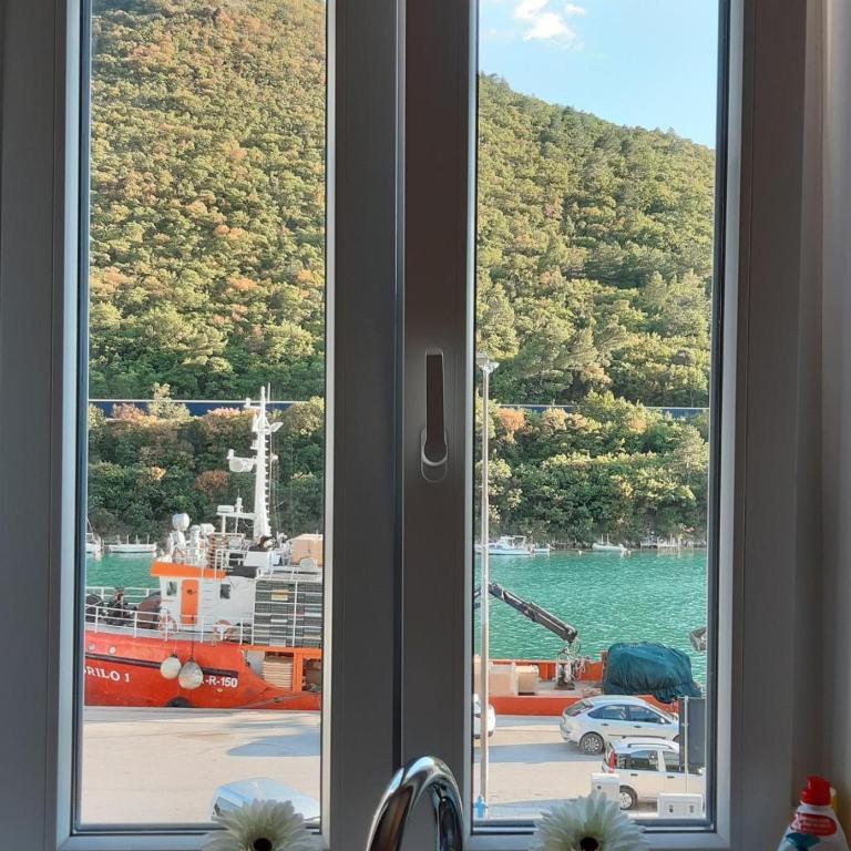 a window with a view of a ship in the water at Apartment Lucie in Plomin