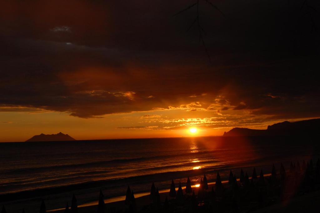 a sunset over the ocean with the sun setting at Beachside House in Sperlonga