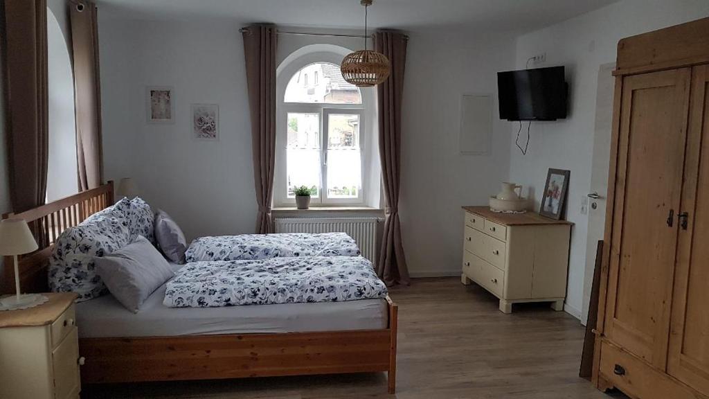 a bedroom with a bed and a window at Ferienwohnung Kaffestübchen 