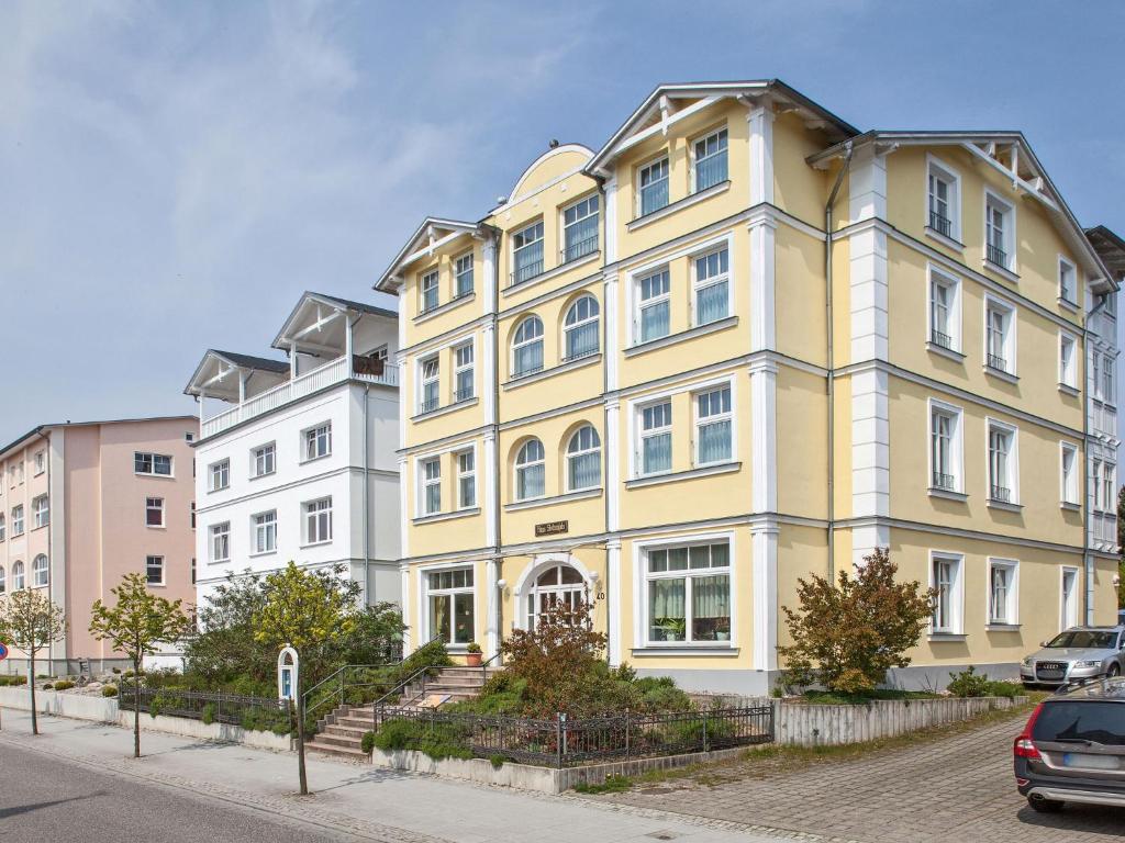 a yellow and white building on a city street at Apartment Stolzenfels-2 by Interhome in Ostseebad Sellin