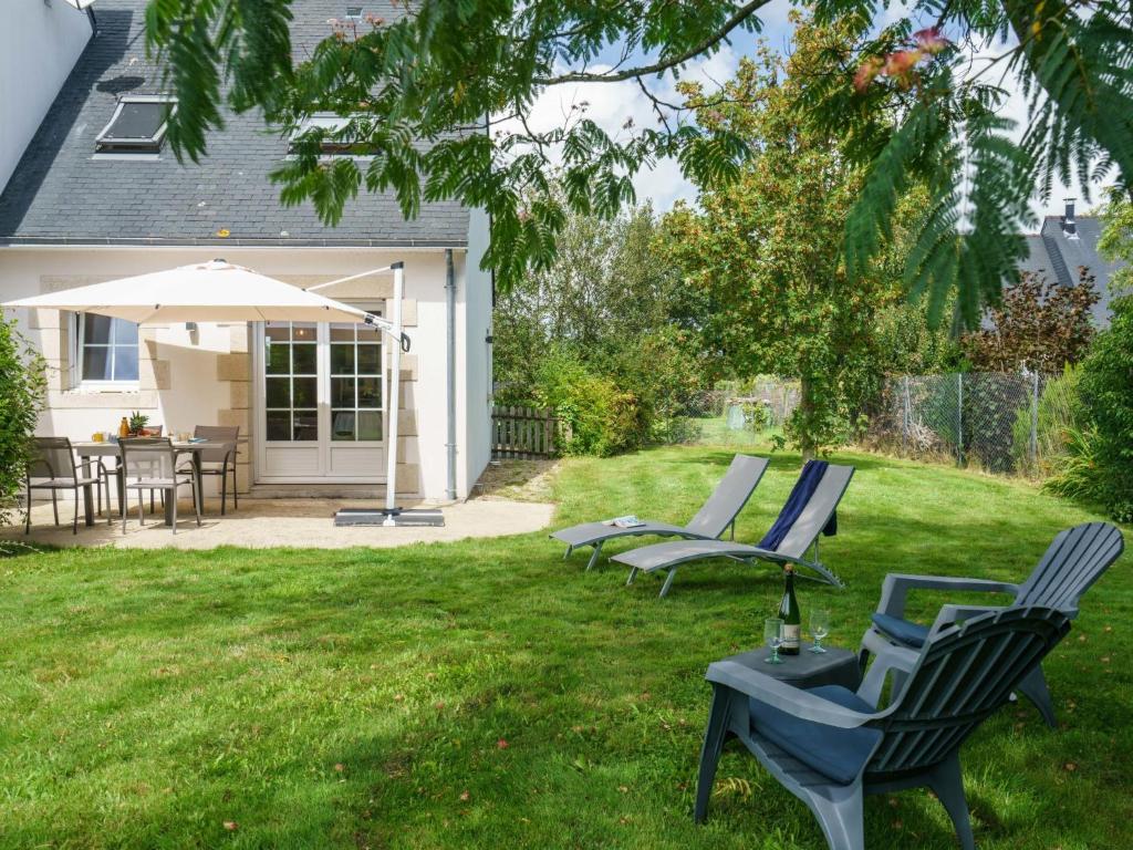 a yard with chairs and an umbrella and a table at Holiday Home La Marinière Izella - SNR101 by Interhome in Sainte-Marine