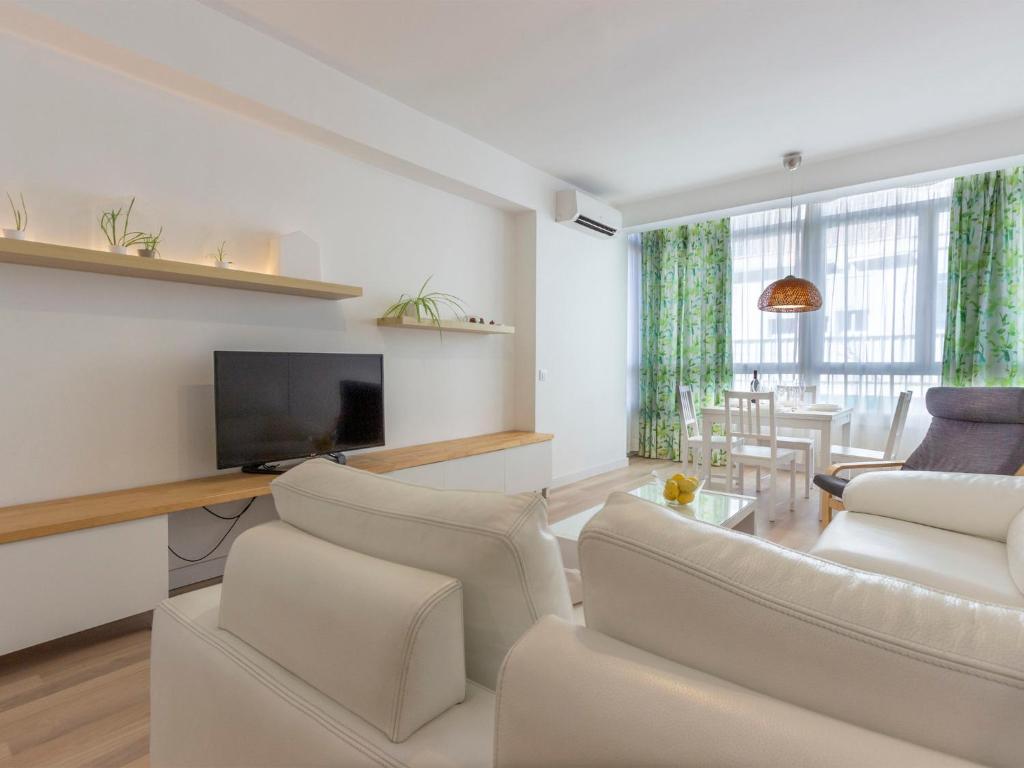 a living room with white furniture and a flat screen tv at Apartment Chamartin-Ciudad Ramos Carrion by Interhome in Madrid