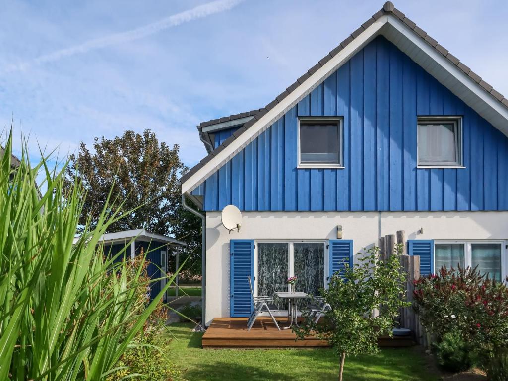 a blue and white house with a deck at Holiday Home Achterblick 2 by Interhome in Altefähr