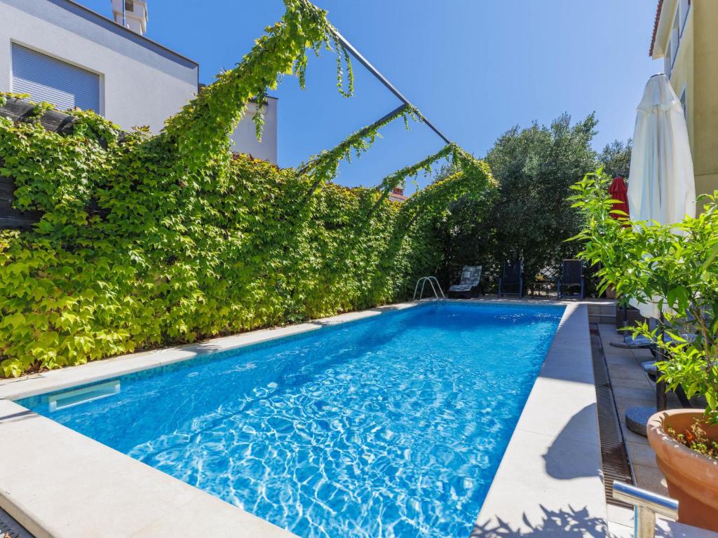 a swimming pool with ivy on the side of a house at Apartment Gabi - MDN152 by Interhome in Ližnjan
