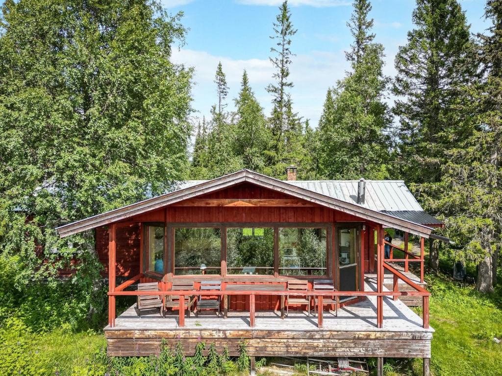 a wooden cabin with a table and chairs in a field at Chalet Högvallen Elden - JAM025 by Interhome in Undersåker