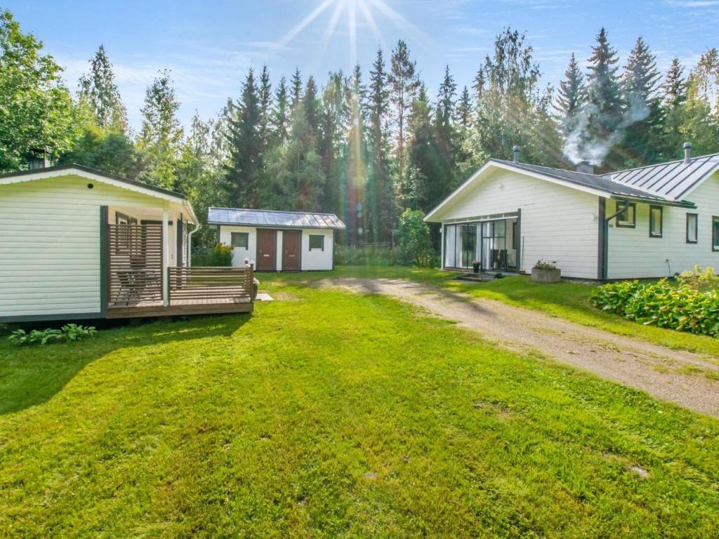 a yard with two small buildings and a house at Holiday Home Eteläaho by Interhome in Nykälä
