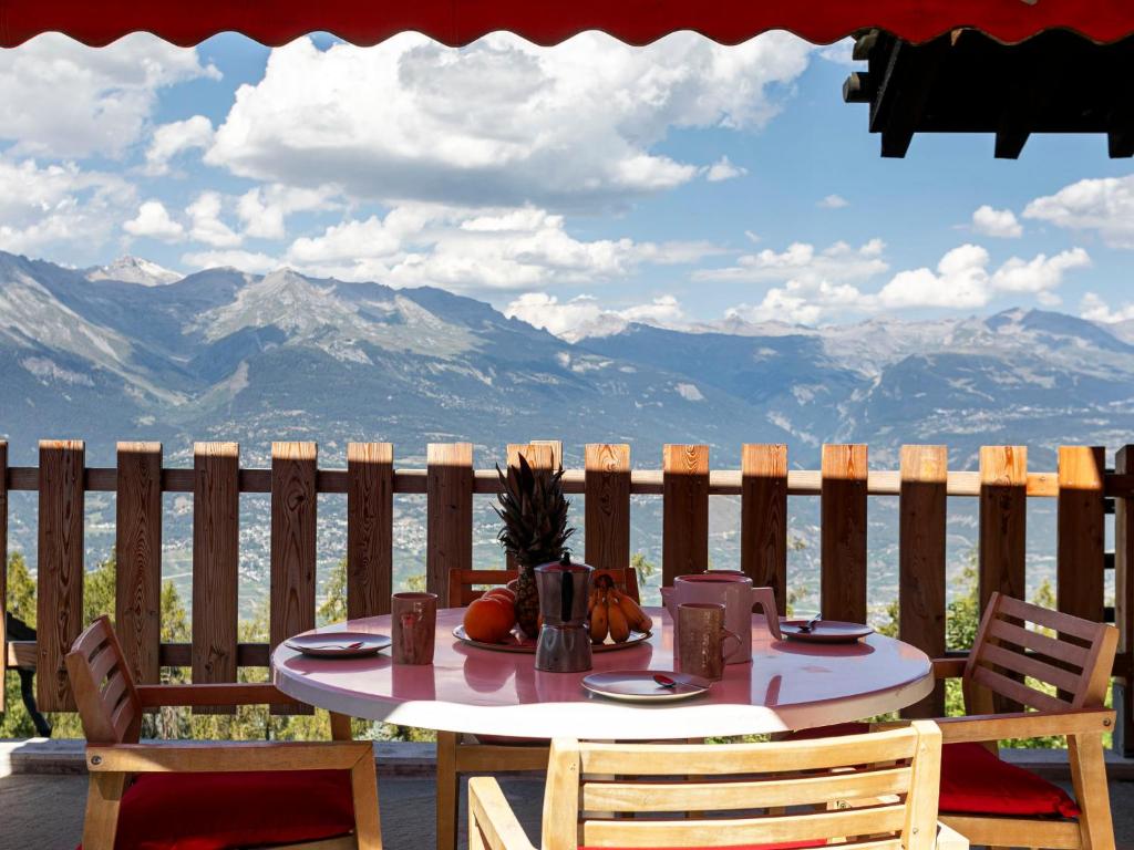 a table on a patio with a view of mountains at Chalet Mayens by Interhome in Agettes