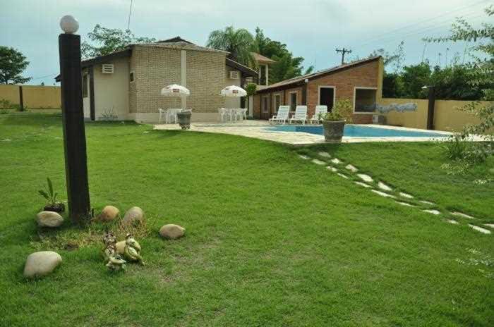 a yard with a house and a swimming pool at POUSADA PEQUIZEIRO in Chapada dos Guimarães