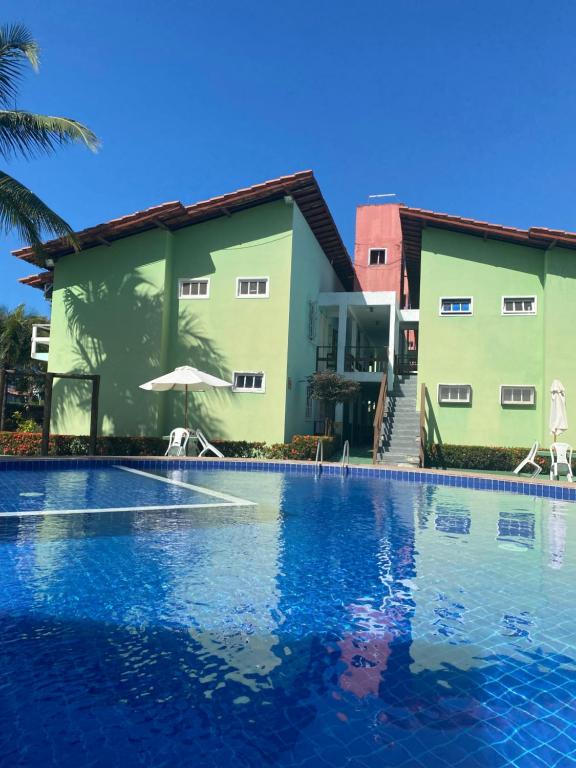 a swimming pool in front of a building at Village Taperapuan in Porto Seguro