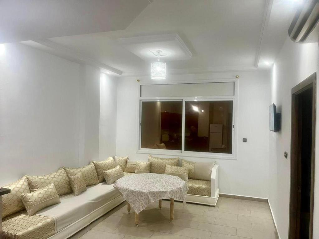 - un salon blanc avec un canapé et une table dans l'établissement Bel Appartement, à Oujda