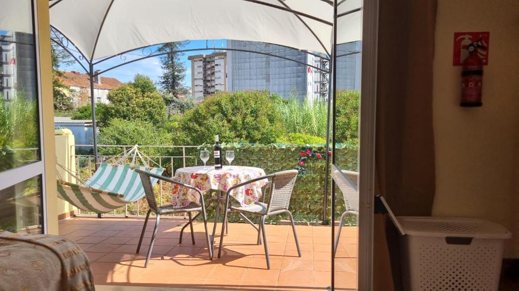 d'une terrasse avec une table et des chaises sur un balcon. dans l'établissement Casa Anjos, à Coimbra