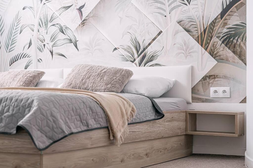 a bedroom with a bed with a tropical wallpaper at Apartments by Pyramid: Christoph in Bratislava