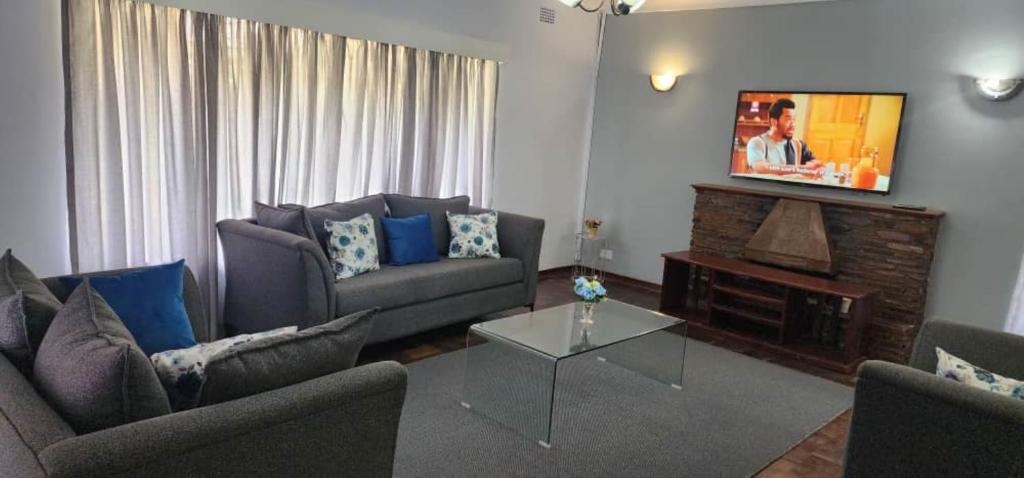 uma sala de estar com dois sofás e uma televisão em Lovely 3 bed in Mount Pleasant - 2153 em Kingsmead