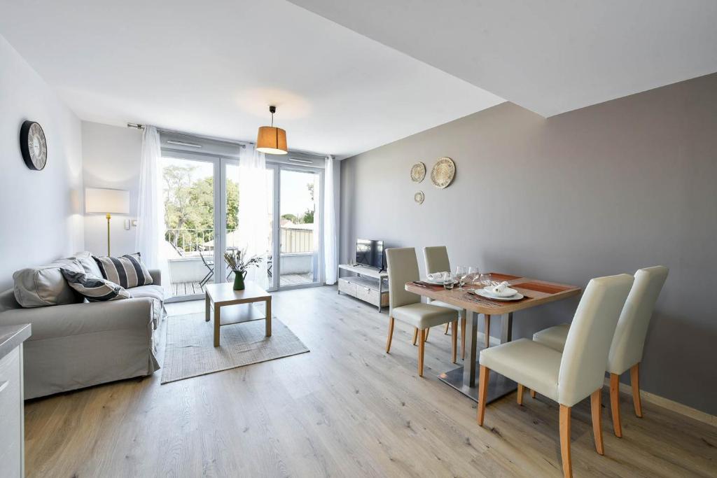 a living room with a table and a couch at OVELIA Toulouse - Les Bastides de Lardenne in Toulouse