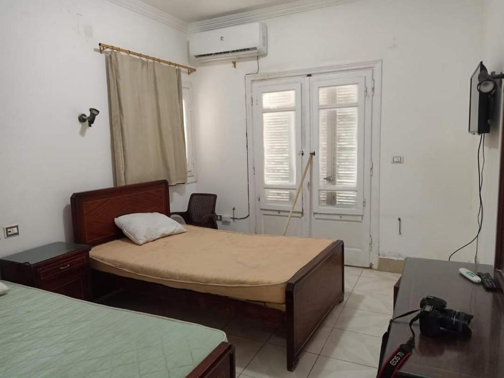 een kleine kamer met 2 bedden en een televisie bij فلا ١٨٦ in Alexandrië