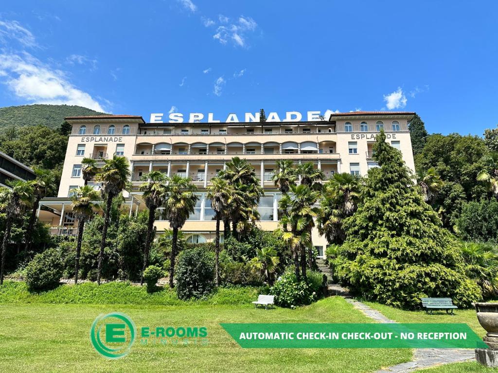 a building with palm trees in front of it at E-Rooms Minusio in Locarno