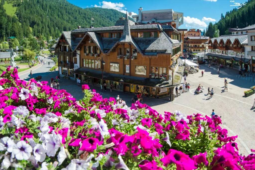 a large building with pink flowers in front of it at [Campiglio] Appartamento Cristallo in Madonna di Campiglio