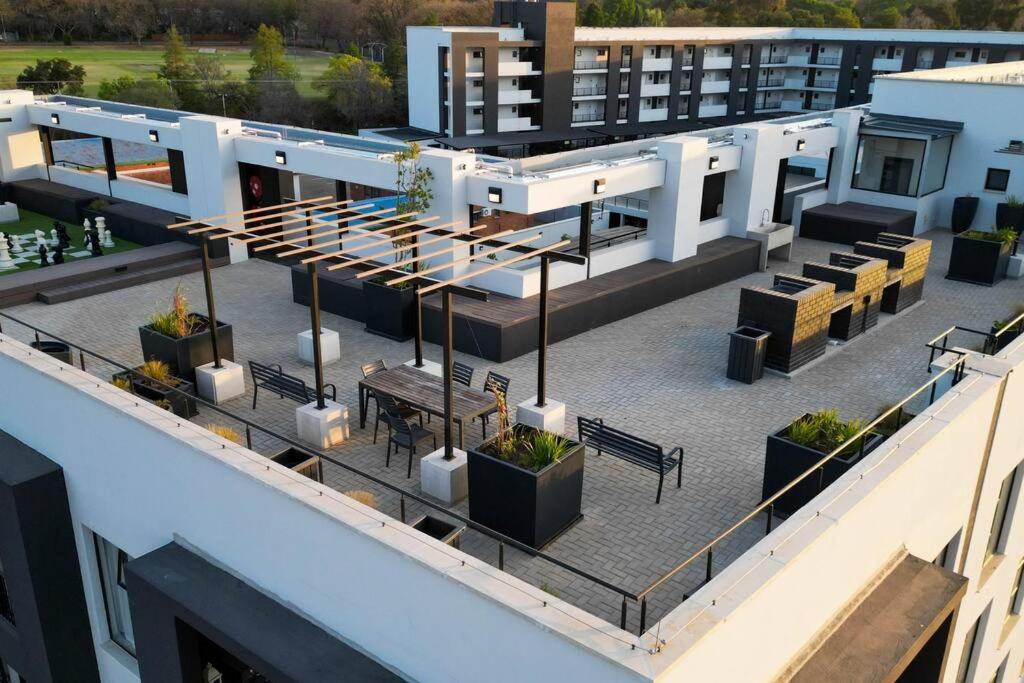 an aerial view of a building with tables and benches at Apartments at Brooklyn/Waterkloof in Pretoria