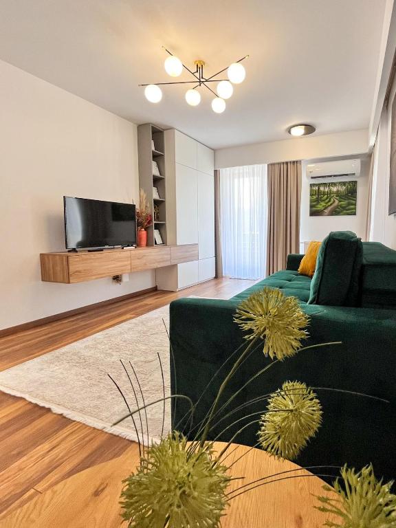 a living room with a green couch and a television at Alegria Avantgarden Brasov in Braşov