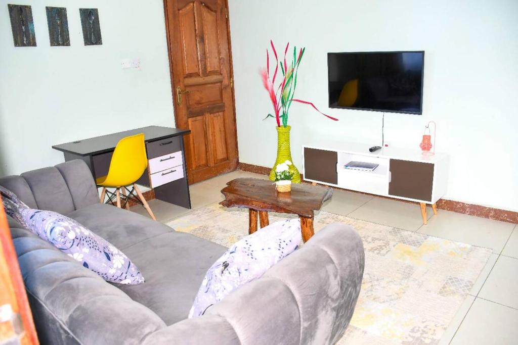 uma sala de estar com um sofá e uma televisão em Urban Oasis em Kakamega