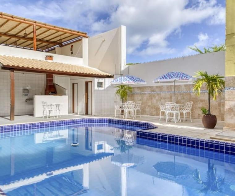 a swimming pool in front of a house at Pousada Maristella in Salvador